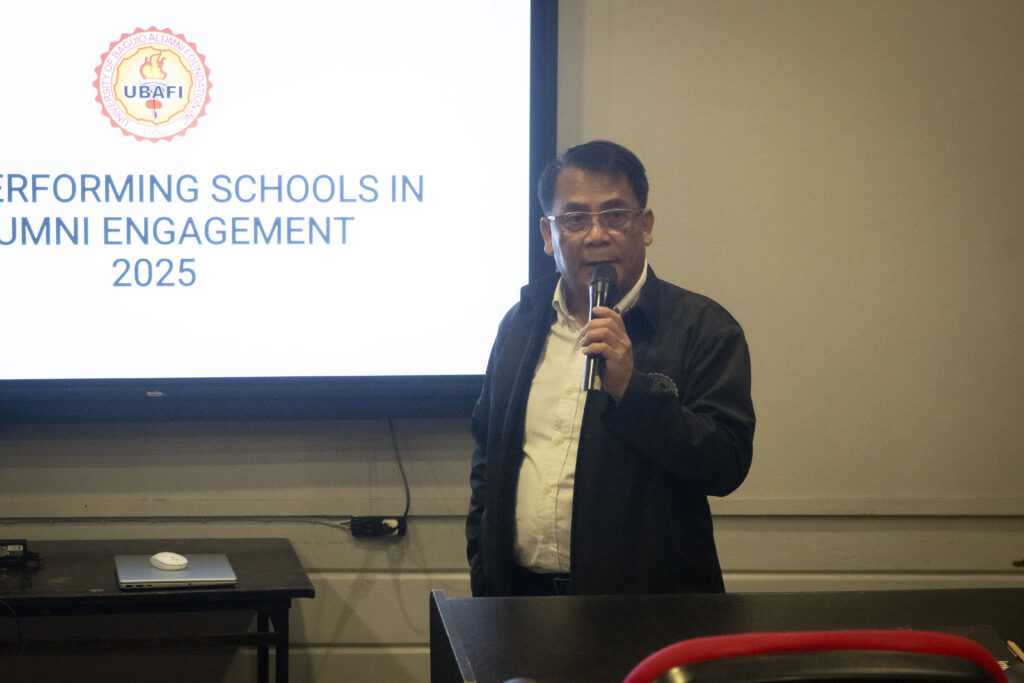 Engr. Eleazer Demayo is seen standing in front of the SMART TV screen of the AVR, with the text "Top Performing Schools in Alumni Engagement 2025" and the UBAFI logo displayed on it.